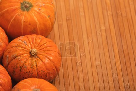 Photo for Autumn orange halloween pumpkins on bamboo planks background. Concept Halloween celebration background, fall harvest, minimalism holiday decoration template. Top view, flat lay, copy space - Royalty Free Image