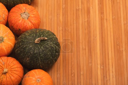 Photo for Autumn colorful halloween pumpkins on bamboo planks background. Concept Halloween celebration background, fall harvest, minimalism holiday decoration template. Top view, flat lay, copy space - Royalty Free Image