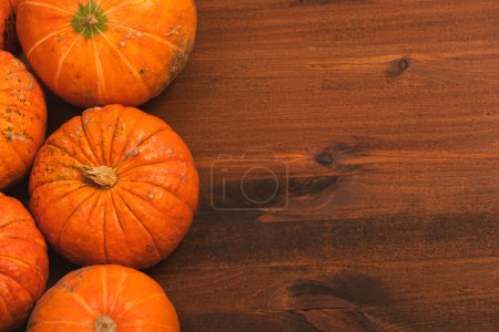 Photo for Autumn orange halloween pumpkins over rustic wooden background. Concept Halloween celebration background, fall harvest, minimalism holiday decoration template. Top view, flat lay, copy space - Royalty Free Image