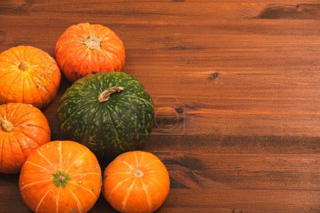 Photo for Autumn colorful halloween pumpkins over rustic wooden background. Concept Halloween celebration background, fall harvest, minimalism holiday decoration template. Top view, flat lay, copy space - Royalty Free Image