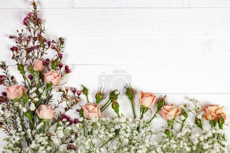 Photo for Flatlay arrangement of branches and flowers on a white rustic wooden tabletop, creating a charming and natural composition - Royalty Free Image