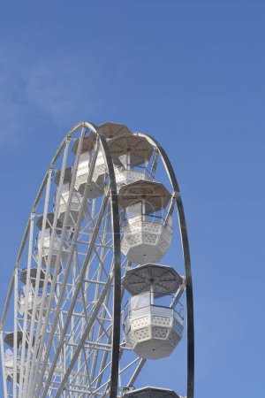 Detail of a white ferris wheel against blue sky
