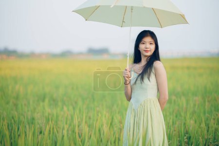 Téléchargez les photos : Fille brune détendue marchant sur les rizières - en image libre de droit