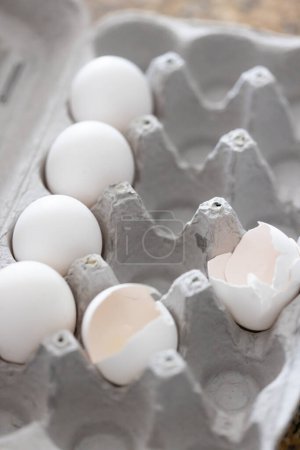 Foto de Carton of White Chicken Eggs and Egg Shells. - Imagen libre de derechos
