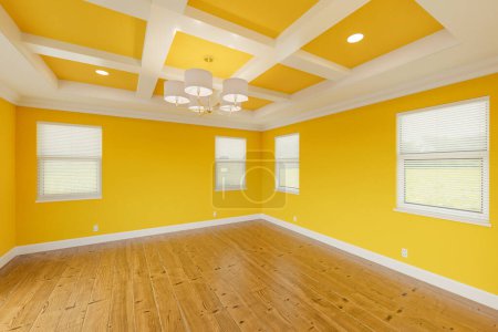 Téléchargez les photos : Belle chambre principale personnalisée jaune audacieux avec peinture fraîche, moulage de la couronne et de la base, planchers de bois dur et plafond offert - en image libre de droit