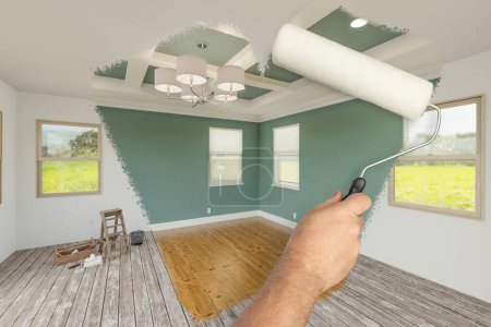Photo for Before and After of Man Using A Paint Roller to Reveal Newly Remodeled Room with Fresh Muted Teal Paint, Coffered Ceiling and New Floors. - Royalty Free Image