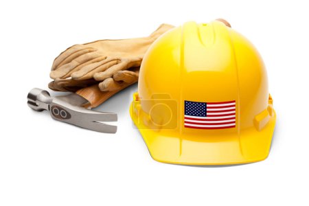 Téléchargez les photos : Chapeau rigide jaune avec décalque drapeau américain sur le devant avec marteau et gants isolés sur fond blanc. - en image libre de droit