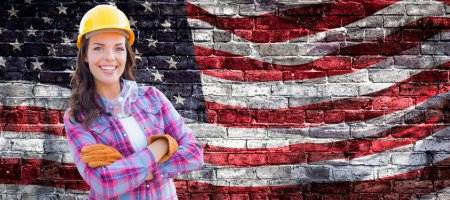 Photo for Female Contractor Wearing Blank Yellow Hardhat and Gloves Over Waving American Flag On Brick Wall Background Banner. - Royalty Free Image