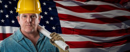 Téléchargez les photos : Homme entrepreneur portant un casque jaune blanc sur le drapeau américain brandissant la bannière arrière-plan. - en image libre de droit