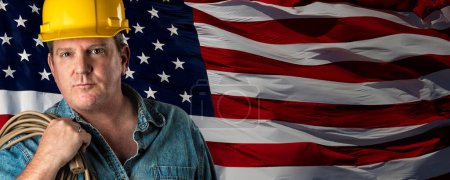 Téléchargez les photos : Homme entrepreneur portant un casque jaune blanc sur le drapeau américain brandissant la bannière arrière-plan. - en image libre de droit