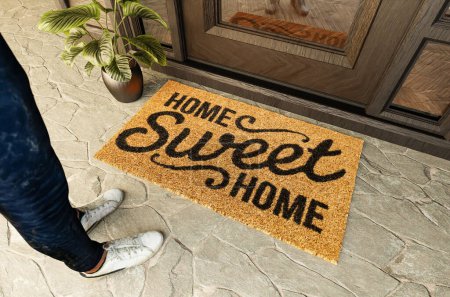Foto de Home Sweet Home felpudo y zapatos de un hombre parado en el porche en la puerta principal. - Imagen libre de derechos