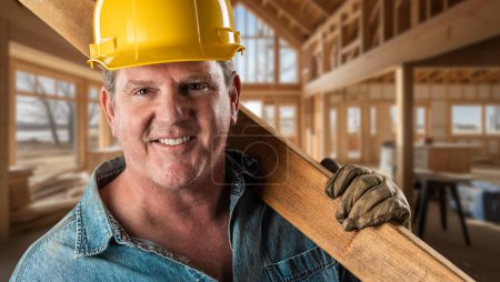 Téléchargez les photos : Charmant entrepreneur masculin amical sur un chantier de construction portant un chapeau dur et des gants de travail - en image libre de droit