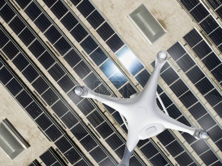 Overhead Aerial view of a Drone Flying over an Industrial Warehouse Roof Covered in Solar Panels.