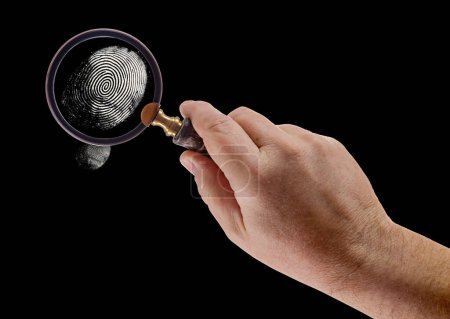 Photo for Male Hand Holding Magnifying Glass Viewing A Fingerprint on a Black Background. - Royalty Free Image