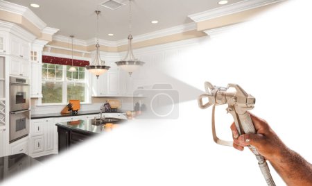 Téléchargez les photos : Peintre de pulvérisation professionnelle tenant pistolet pulvérisateur pulvérisation nouvelle cuisine rénovée sur surface blanche. - en image libre de droit