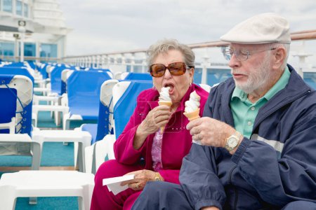 Téléchargez les photos : Heureux couple de personnes âgées appréciant la crème glacée sur le pont d'un navire de croisière à passagers de luxe. - en image libre de droit