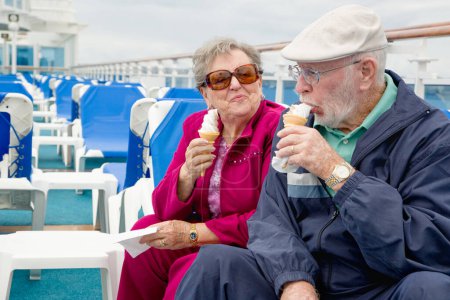 Photo for Happy Senior Adult Couple Enjoying Ice Cream On The Deck of a Luxury Passenger Cruise Ship. - Royalty Free Image