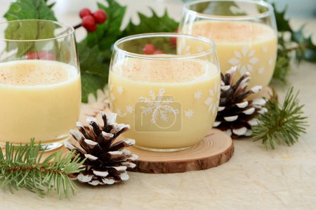 Traditional eggnog in festive Christmas setting. Horizontal format with selective focus on center glass