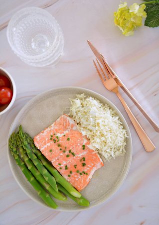 Fresh caught Pacific Ocean coho salmon filet in flat lay composition with asparagus and rice.  Healthy source of Omega 3.  