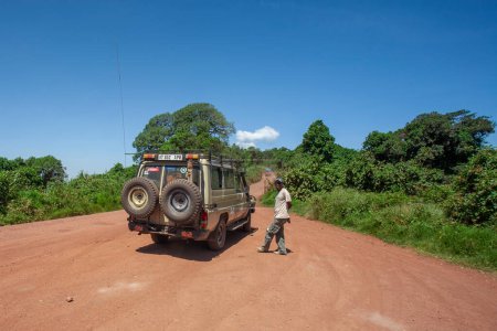 Téléchargez les photos : Homme près de la voiture sur la route à savane africaine - en image libre de droit