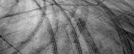 Foto de Black tire tracks or marks from driving on cement drive - Imagen libre de derechos