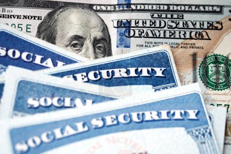 Téléchargez les photos : Plusieurs cartes de sécurité sociale sur un billet de cent dollars des États-Unis Système de prestations de 100 $pour les personnes âgées à la retraite - en image libre de droit