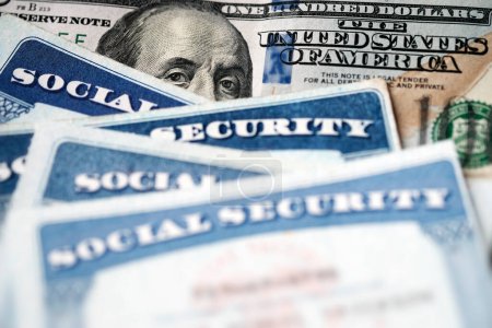 Foto de Varias tarjetas de Seguro Social en un billete de cien dólares de los Estados Unidos $100 sistema de beneficios para las personas mayores jubiladas - Imagen libre de derechos