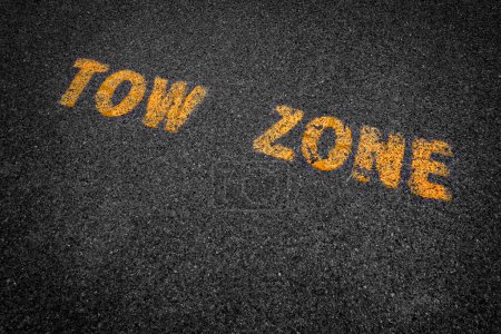 Photo for Detail of tow zone sign pained in yellow on asphalt parking area - Royalty Free Image