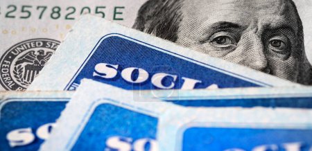 Téléchargez les photos : Plusieurs cartes de sécurité sociale sur un billet de cent dollars des États-Unis Système de prestations de 100 $pour les personnes âgées à la retraite - en image libre de droit
