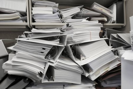 Photo for Messy office with pile of binders holding papers and filings disorganized mess - Royalty Free Image