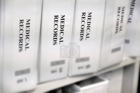 Medical records organized in binders on shelf for record keeping