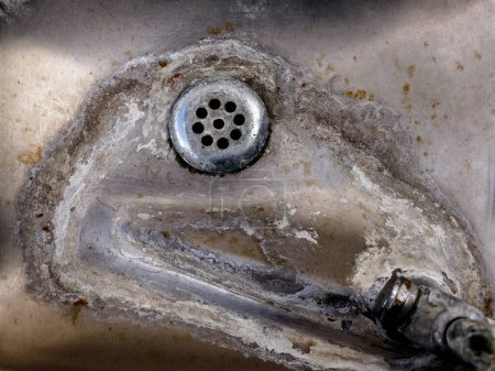Foto de Fuente de bebida manchada de agua vieja en fregadero de acero con desagüe - Imagen libre de derechos
