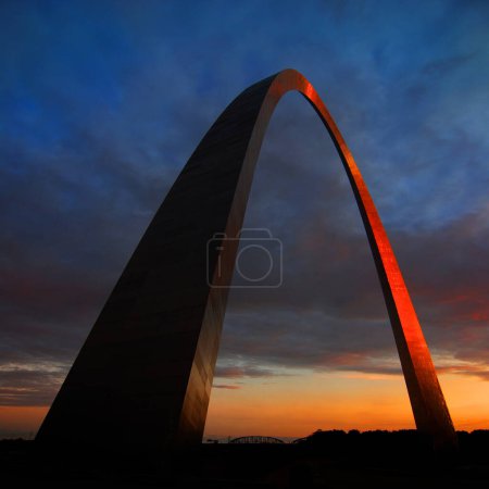 St Louis Arch landmark metal gateway sunset glowing orange with a blue sky