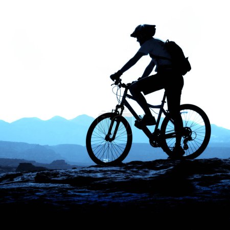 Ciclismo de montaña por un sendero en la silueta del jinete de las montañas silueta en la cresta
