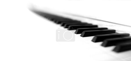 Bright white Piano keys on old musical instrument with high tone ebony and ivory close up panoramic