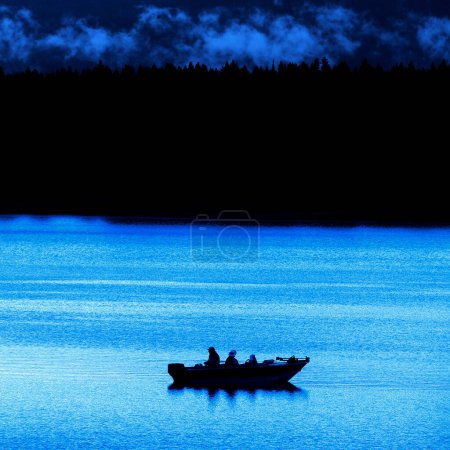 Pescadores en un barco en un lago por la noche o temprano en la mañana