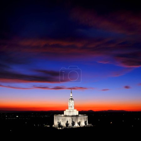 Pocatello Idaho LDS Mormón Último Día Saint Temple al atardecer con luces brillantes y árboles