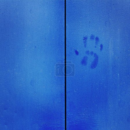 Detail of blue doors with handles and handprint hand print texture