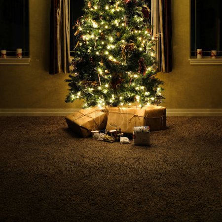 Téléchargez les photos : Arbre de Noël dans la maison salon avec des cadeaux enveloppés aux fenêtres de nuit - en image libre de droit