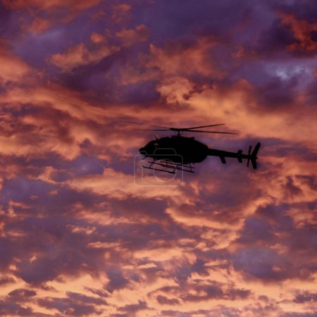 Téléchargez les photos : Hélicoptère volant Scène de coucher ou de lever du soleil dans le ciel nuages dramatiques avec des montagnes - en image libre de droit