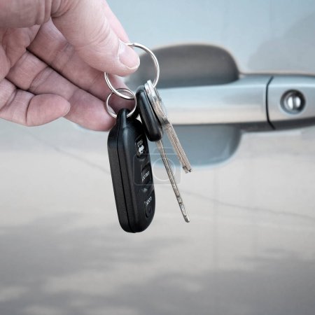 Téléchargez les photos : Clés de voiture portatives devant la porte de voiture grise - en image libre de droit