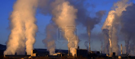 Téléchargez les photos : Cheminées d'usine crachant la pollution dans le ciel fumées polluants en hausse dans l'air - en image libre de droit