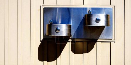 Téléchargez les photos : Fontaine à boire en acier montée sur mur pour un usage public - en image libre de droit