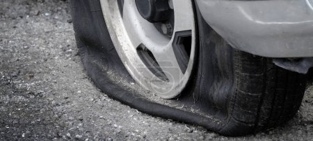 Photo for Stranded with a flat tire on roadway car vehicle cannot move deflated - Royalty Free Image