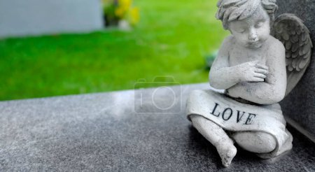 Statue en marbre antique d'un ange chérubin avec mot amour sculpté dans la pierre symbole d'une relation durable