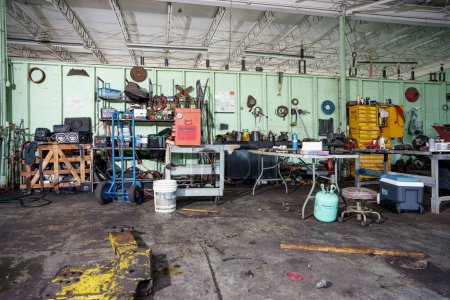 Téléchargez les photos : Miami, FL, USA - Octobre 18, 2022 : Vieux garage de réparation de voiture salissant avec des pièces et des outils tout autour - en image libre de droit