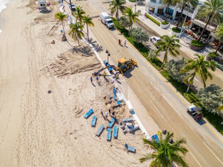 Téléchargez les photos : Fort Lauderdale Beach le lendemain de l'ouragan Nicole avec des équipes de nettoyage enlevant le sable de la route - en image libre de droit
