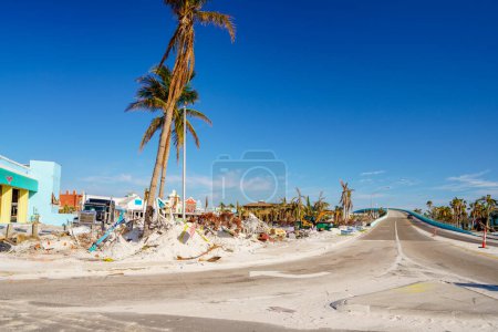 Photo for Fort Myers Beach, FL, USA - November 19, 2022: Fort Myers Beach view down San Carlos Blvd Matanzas Pass Bridge debris piles on the streets from Hurricane Ian - Royalty Free Image