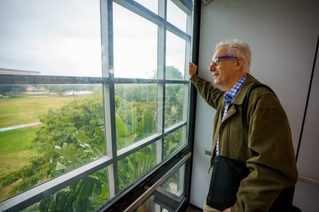 Foto de PHoto of a college professor looking out of an elevator window view - Imagen libre de derechos