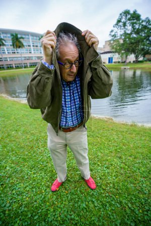 Photo for Old college professor hiding under his jacket - Royalty Free Image